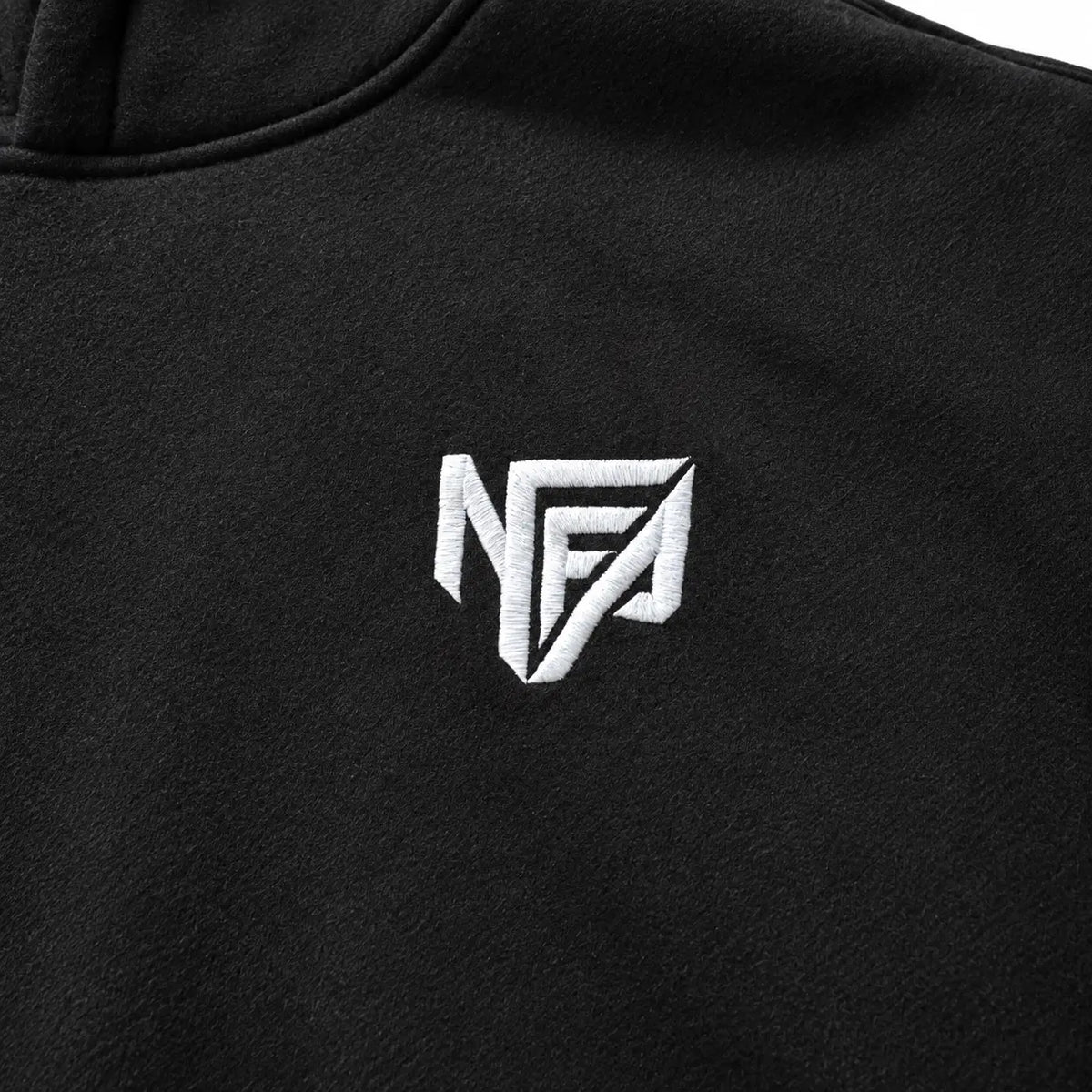 Close-up of the white embroidered NFA logo on the black hoodie chest